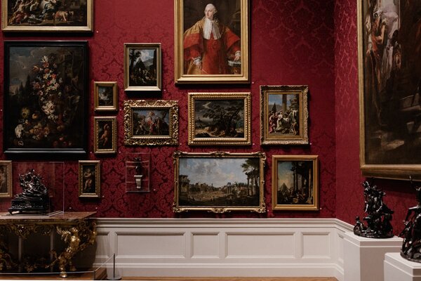 Classical art gallery wall with red damask wallpaper and framed paintings